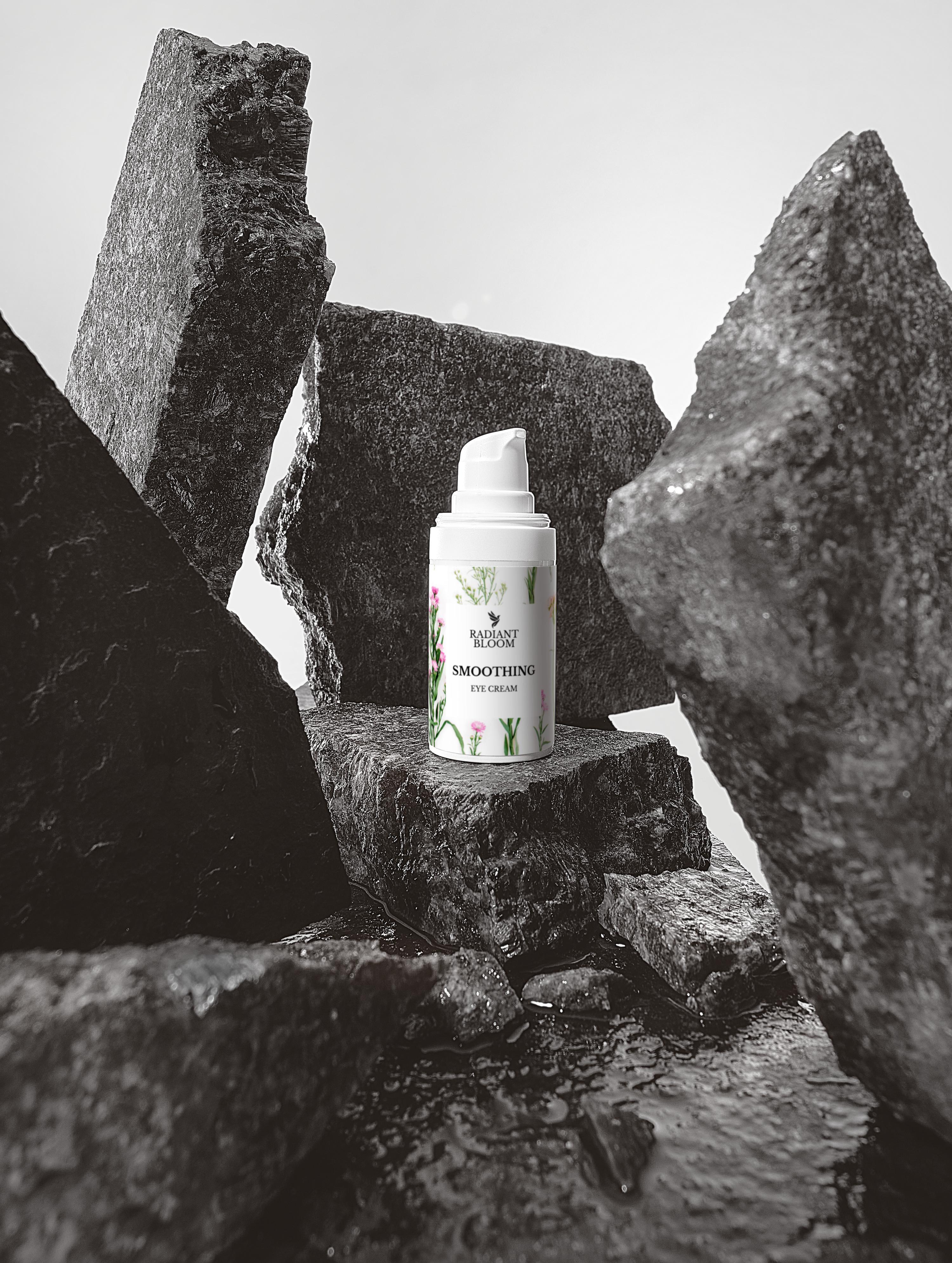 Eye cream bottle with pump centered among gray stones, floral label on white.